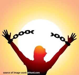 girl with raised hands and broken chains