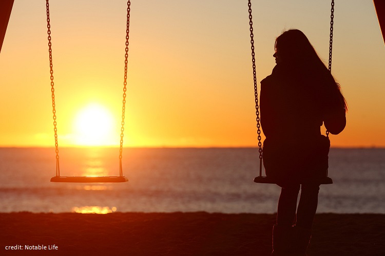 Single Woman Alone Swinging On The Beach